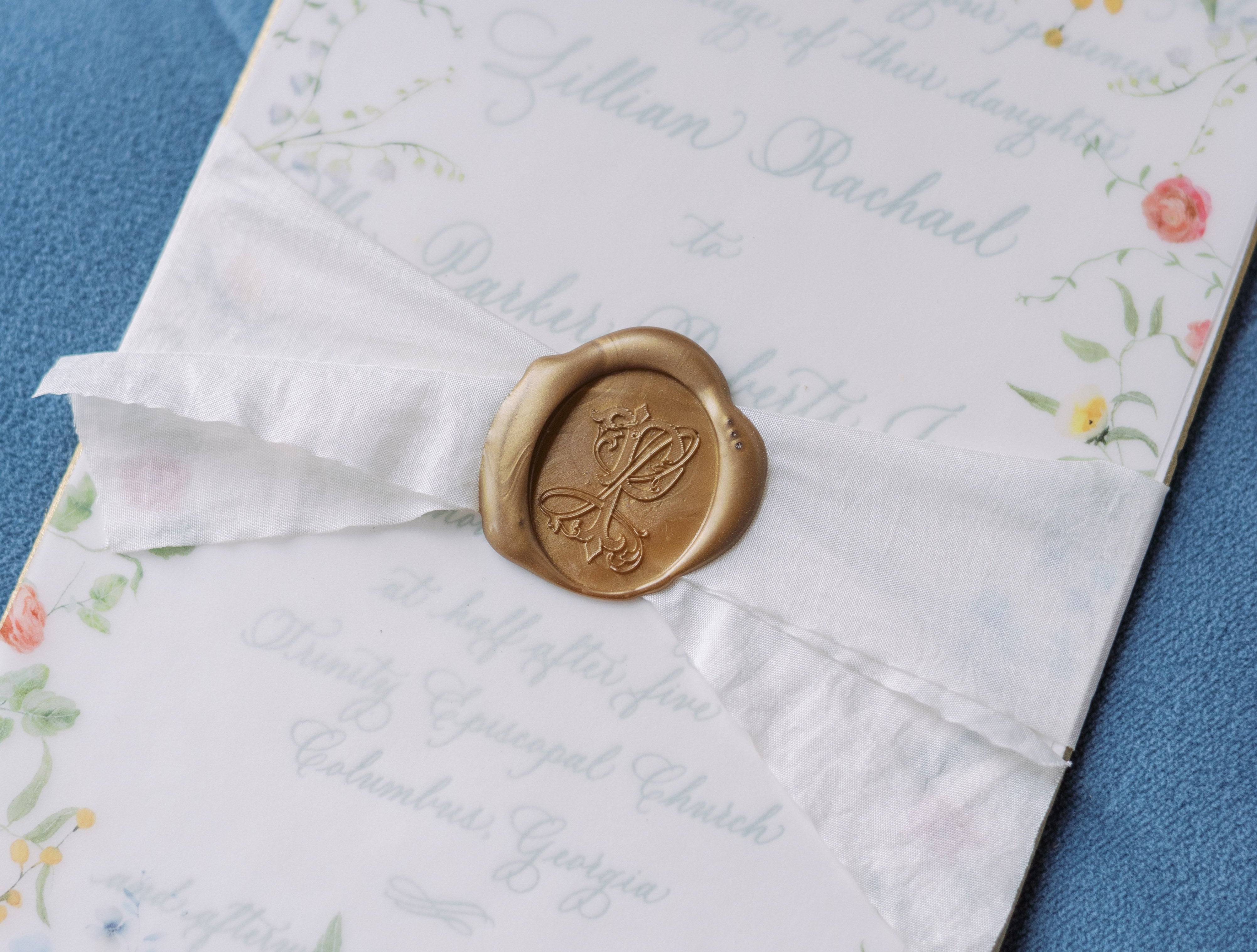 Floral-patterned letter with a wax seal on a blue fabric background